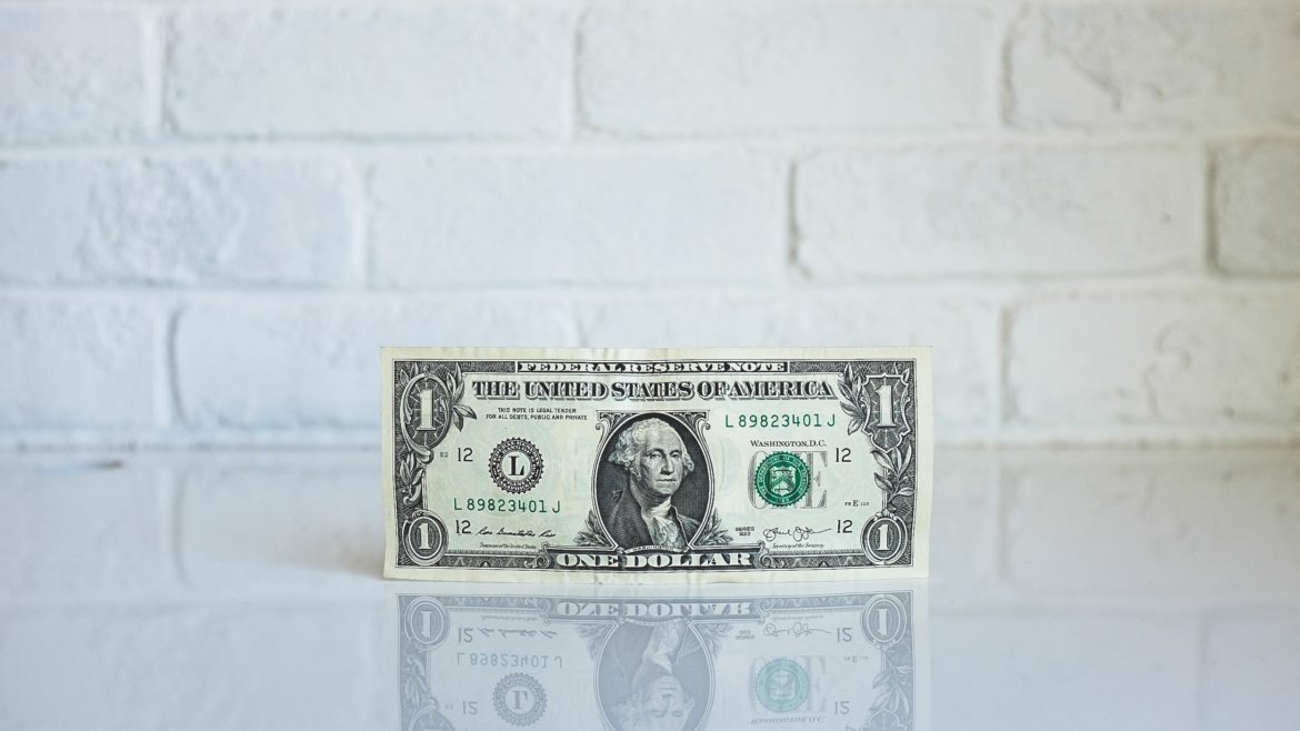 A one dollar bill is photographed in front of a white background. - PayReel