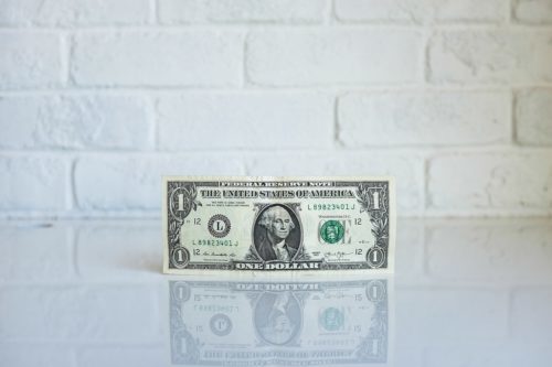 A one dollar bill is photographed in front of a white background. - PayReel