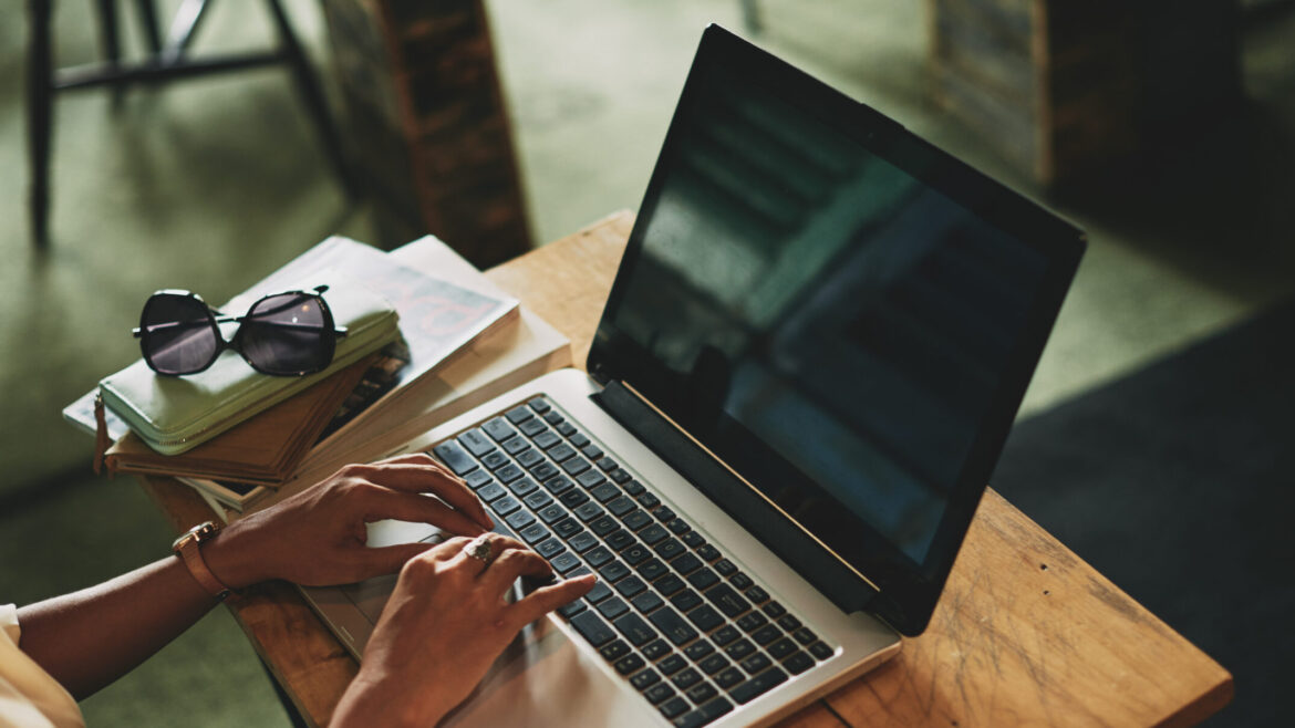Woman working remotely in cafe on laptop